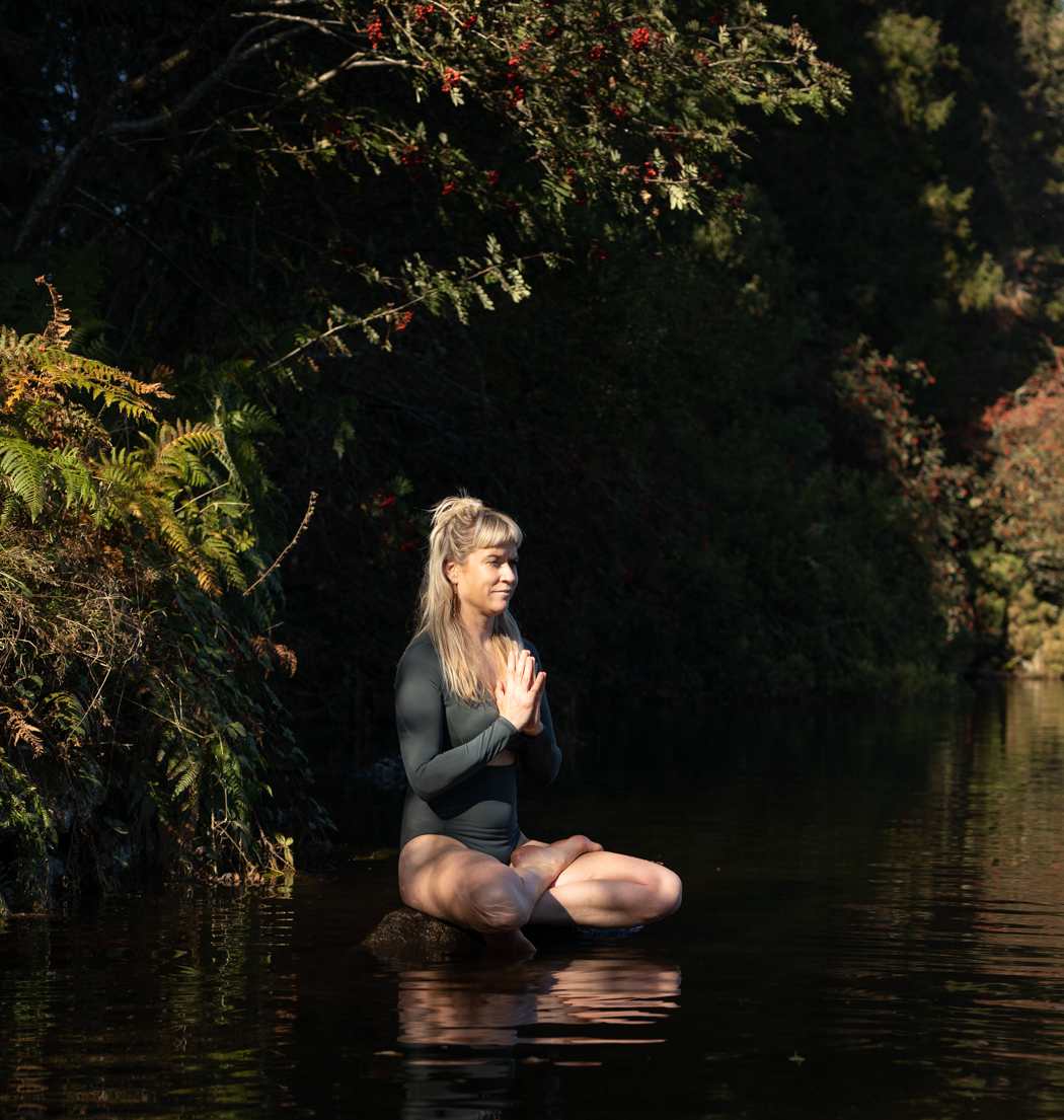 Gina meditating by the river